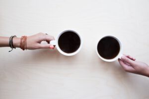 twee handen die een kop koffie vasthouden