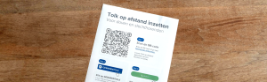 Poster op houten achtergrond, op de poster staat de tekst "Tolk op afstand"
