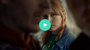 Vrouw kijkt naar twee mannen. afspeelknop.