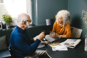 man en een vrouw hebben gesprek aan tafel