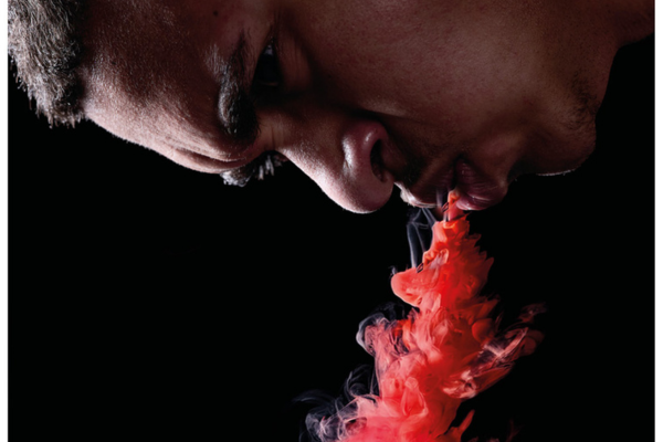 Man blaast rode rook uit