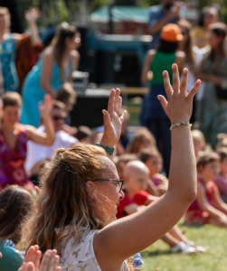 Groep mensen die handen in de lucht steken.