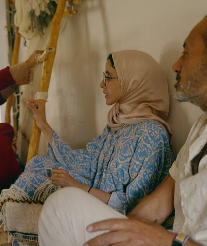 Vrouw met hoofddoek maakt gebaar, man kijkt naar vrouw