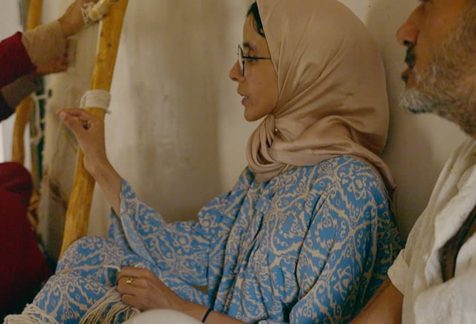 Vrouw met hoofddoek maakt gebaar, man kijkt naar vrouw