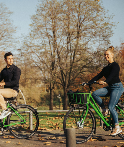 Man en vrouw op fietsen, fietsen door een park