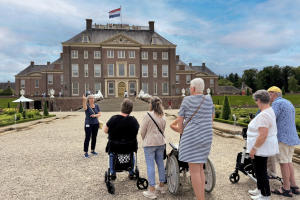 Bezoekers luisteren naar de gids in de paleistuin van Het Loo